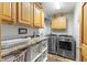 Functional laundry room with wooden cabinets, granite countertops, and modern washer/dryer at 12129 N Cedarview Dr, Mooresville, IN 46158