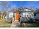 Charming single-story home with gray siding and a vibrant orange front door at 1246 Mcdougal St, Indianapolis, IN 46203