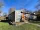 Charming, gray cottage-style home featuring an inviting orange front door and well-maintained landscaping at 1246 Mcdougal St, Indianapolis, IN 46203