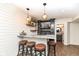 Finished basement bar area featuring granite counters, a sink, pendant lighting, and seating at 12569 Branford St, Carmel, IN 46032
