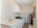 Well-equipped laundry room with ample storage, sink, and modern washer and dryer at 12569 Branford St, Carmel, IN 46032