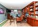 Well-lit home office with wooden desk, bookshelves, a tv, and sports memorabilia on display at 12569 Branford St, Carmel, IN 46032