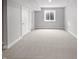 Unfinished basement space offers versatility with light gray walls, neutral carpet, and a single window at 13820 N Honey Creek Dr, Camby, IN 46113