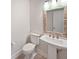 Bathroom featuring a pedestal sink, toilet, and a uniquely tiled mirror at 13820 N Honey Creek Dr, Camby, IN 46113