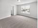 A bright bedroom with neutral carpet, a large window and a door to the hallway at 13820 N Honey Creek Dr, Camby, IN 46113