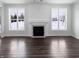 Bright living room featuring modern fireplace, dark hardwood floors and windows overlooking outdoors at 13820 N Honey Creek Dr, Camby, IN 46113