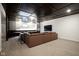 Finished basement features a TV and a custom seating area in addition to a brown leather sofa at 13947 Morningtide Cir, Fishers, IN 46038