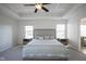 Bright bedroom featuring a tray ceiling, large windows, and a comfortable bed with stylish linens at 13947 Morningtide Cir, Fishers, IN 46038