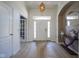 Welcoming foyer with light hardwood floors, chandelier, and arched doorway detail at 13947 Morningtide Cir, Fishers, IN 46038