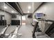 Well-equipped home gym with mirrors, a treadmill, and multiple wall-mounted televisions at 13947 Morningtide Cir, Fishers, IN 46038