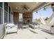Inviting covered patio features a brick fireplace, ceiling fan, and comfortable seating, ideal for outdoor relaxation at 13947 Morningtide Cir, Fishers, IN 46038