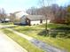 View of home with a well-maintained lawn and established trees, with a street and neighboring houses visible at 1405 Creekside Dr, Brownsburg, IN 46112