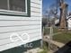 Home exterior side showing access to backyard with lush greenery and privacy fence at 1405 N Mount St, Indianapolis, IN 46222