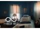 Bedroom with blue walls, natural lighting, and curtained windows at 1405 N Mount St, Indianapolis, IN 46222