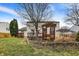 Manicured backyard with a deck, mature trees, and a charming wooden pergola at 15192 Porchester Dr, Noblesville, IN 46062