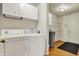 Well-lit laundry room with modern washer and dryer units, storage cabinets, and white door at 15192 Porchester Dr, Noblesville, IN 46062