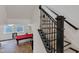 Basement staircase with black and wood banister leading to basement with pool table and egress windows at 1521 Avondale Dr, Westfield, IN 46074