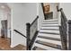 Elegant staircase with black railing and white risers, accented with patterned stair runners at 1521 Avondale Dr, Westfield, IN 46074