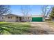 Charming single-story home features a green garage door, a well-maintained lawn, and mature trees at 1620 S East St, Lebanon, IN 46052