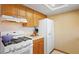 Well-lit kitchen featuring white appliances, wood cabinetry, and a functional layout for cooking at 1620 S East St, Lebanon, IN 46052