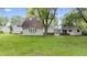 Expansive backyard featuring a lush lawn, mature trees, and a detached outbuilding at 1641 Whistler Terrace, Indianapolis, IN 46229