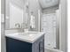 Modern bathroom featuring a glass door shower and vanity with white countertop and navy blue cabinetry at 1641 Whistler Terrace, Indianapolis, IN 46229