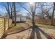 Spacious fenced backyard with new wooden fence, small outbuilding, and mature trees at 1822 N Dexter St, Indianapolis, IN 46202