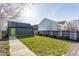 Backyard featuring green grass, a grey shed with a green door, and a partial fence at 1955 Alvord St, Indianapolis, IN 46202