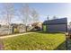 View of backyard with green grass and an enclosed grey shed with a green door at 1955 Alvord St, Indianapolis, IN 46202