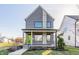 Charming two-story home with a modern design, featuring gray siding, a cozy front porch, and a well-maintained lawn at 1955 Alvord St, Indianapolis, IN 46202