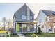 Modern two-story home features gray siding, large windows, and a welcoming porch with a bright green front door at 1955 Alvord St, Indianapolis, IN 46202