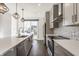 Bright, modern kitchen featuring stainless appliances, gray cabinets, white backsplash, and quartz counters at 1955 Alvord St, Indianapolis, IN 46202