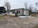 Single-story home with tan siding, green shutters, and a cracked driveway at 209 Crawford St, Clayton, IN 46118