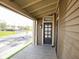 Eye-level front porch showing brown siding, view of street, and a multi-paneled front door at 249 N Hamilton Ave, Indianapolis, IN 46201