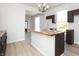 Kitchen island with butcher block countertop, stainless steel sink, dark cabinets and open-concept living area at 249 N Hamilton Ave, Indianapolis, IN 46201