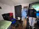 Cluttered bedroom with personal belongings, clothes rack, and dark patterned curtains at 2820 N Gladstone Ave, Indianapolis, IN 46218