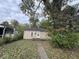 A charming single-story home has a beige exterior and small front entry surrounded by mature trees at 2820 N Gladstone Ave, Indianapolis, IN 46218