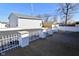 View of the garages and backyard, with a white decorative fence and concrete patio at 32 E Main St, Mooresville, IN 46158
