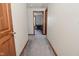 Hallway featuring neutral walls, gray carpet, and wood trim leading to different rooms at 32 E Main St, Mooresville, IN 46158