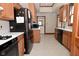 Kitchen with oak cabinets, black appliances, and vinyl flooring at 32 E Main St, Mooresville, IN 46158