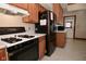 Kitchen features black appliances, oak cabinets, and an overhead vent at 32 E Main St, Mooresville, IN 46158