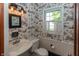 Charming powder room with patterned wallpaper, elegant lighting, and a stylish sink at 3548 W 500 North Rd, McCordsville, IN 46055