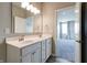 Double vanity bathroom with a large mirror, modern lighting, and an open doorway to the bedroom at 3581 Free Spirit Ct, Westfield, IN 46074