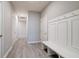 Long hallway with neutral paint and flooring, featuring a built-in bench with coat hooks and multiple doors at 3581 Free Spirit Ct, Westfield, IN 46074