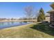 Backyard pond view from a home with a well-maintained lawn and lush green trees at 3792 Waterfront Way, Plainfield, IN 46168