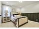 Stylish bedroom featuring a cushioned headboard bed, dark green wainscoting, and neutral color palette at 4052 Saddle Club S Pkwy, Bargersville, IN 46106