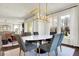 A dining room features a marble table, upholstered chairs and modern light fixture with a view outdoors at 4052 Saddle Club S Pkwy, Bargersville, IN 46106