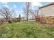Landscaped backyard featuring a deck, stone foundation, and wooden pergola at 4448 Aristocrat Cir, Indianapolis, IN 46235