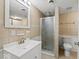 This bathroom features neutral tiling, glass enclosed shower, vanity and toilet at 4448 Aristocrat Cir, Indianapolis, IN 46235