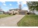 Split-level home showcasing a front yard, a two-car garage, and a combination of stone and siding at 4448 Aristocrat Cir, Indianapolis, IN 46235
